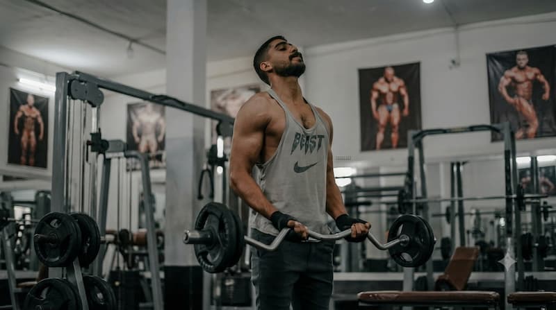 Male athlete lifting barbell in gym with beast mindset representing belief and effort combined for self fulfilling prophecy
