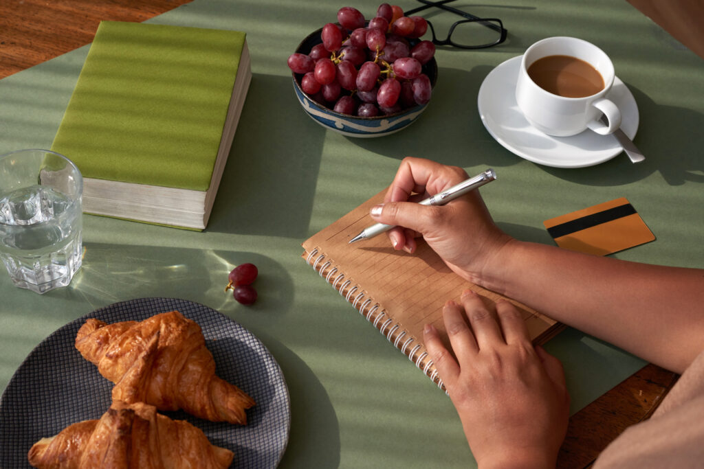 Young professional reflecting on work life balance while journaling at desk